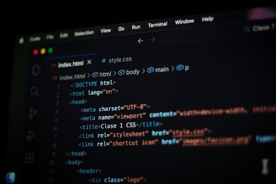 A close-up photograph of a laptop computer placed on a desk, displaying a screen with code written in a text editor alongside a large, orange calculator application. The code appears to be HTML or CSS